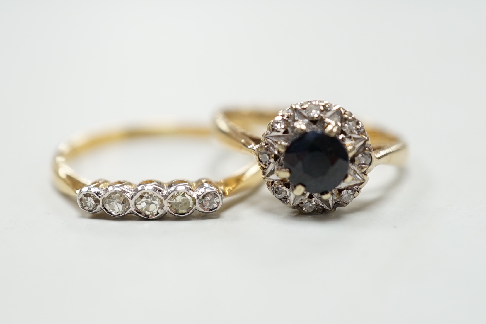 An 18ct and five stone diamond chip set half hoop ring and a modern 9ct gold, sapphire and diamond cluster ring.